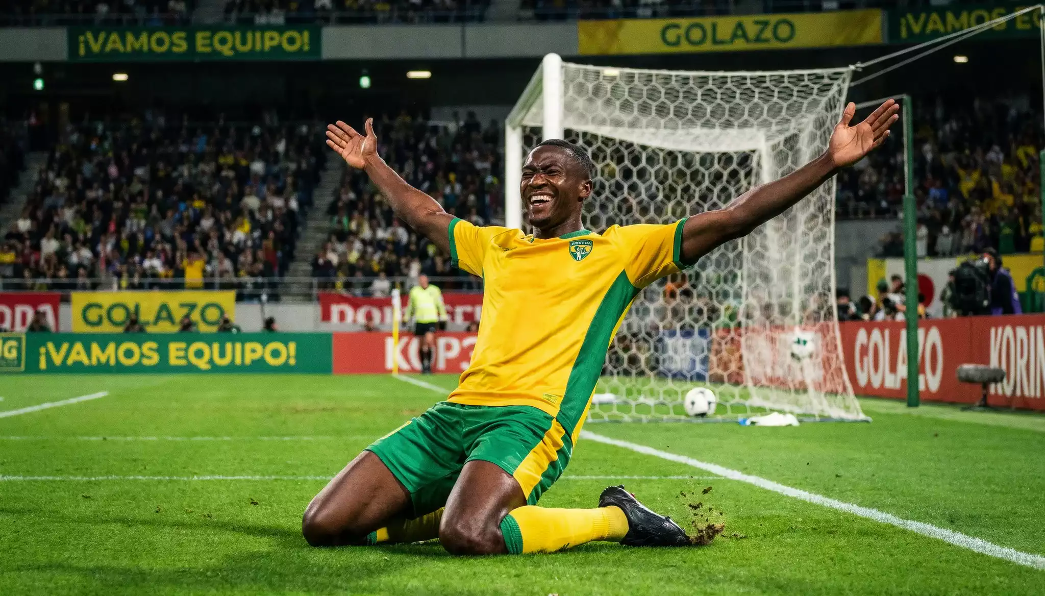 Delantero extranjero celebrando un gol en un estadio de la J.League con gradas llenas