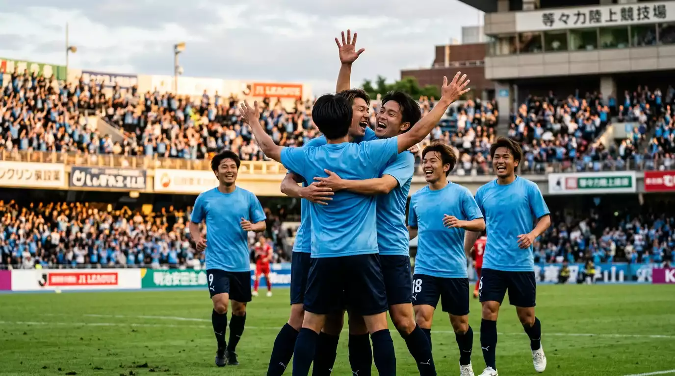 Jugadores con camiseta celeste celebrando un gol en el césped de un estadio de fútbol japonés